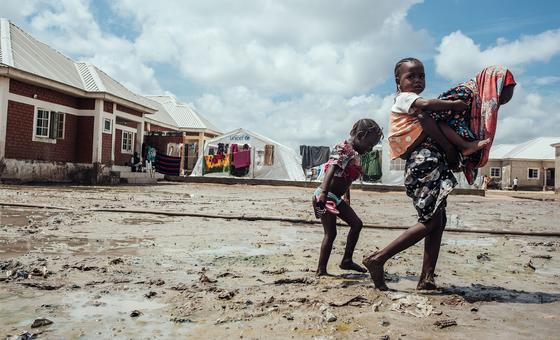在尼日利亚东北部迈杜古里的流离失所者营地中，孩子们走过泥泞。    